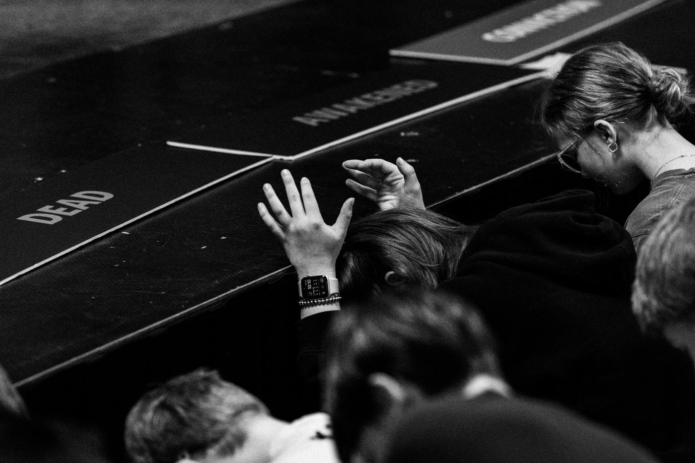 Black and white photo of students raising their hands during a school gathering