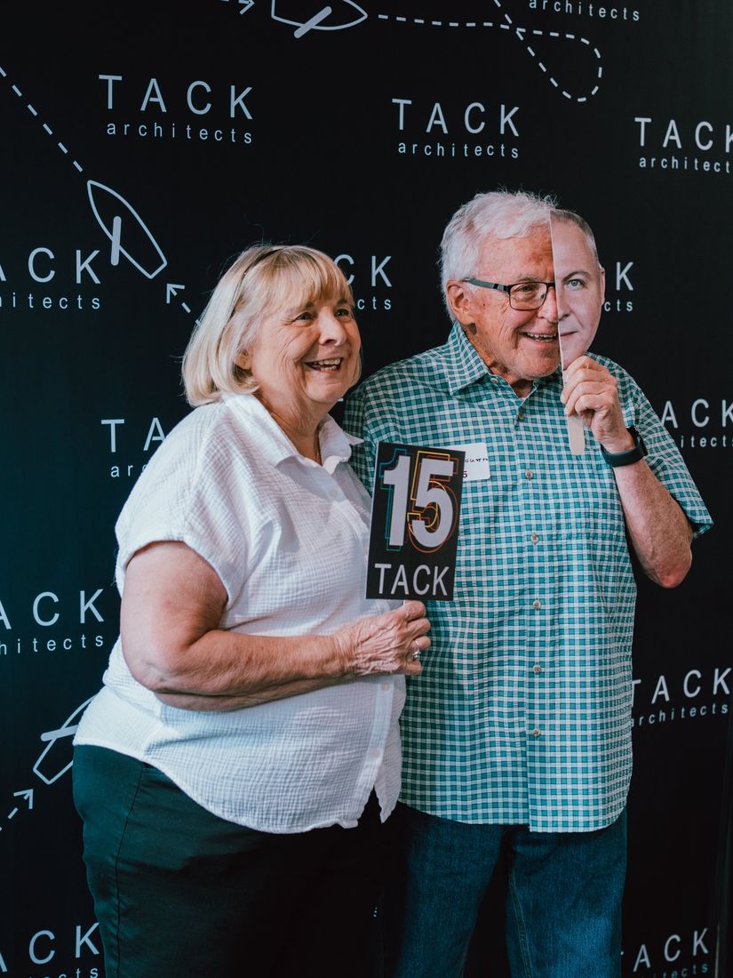 Two guests posing at the TACK 15 photo backdrop with props