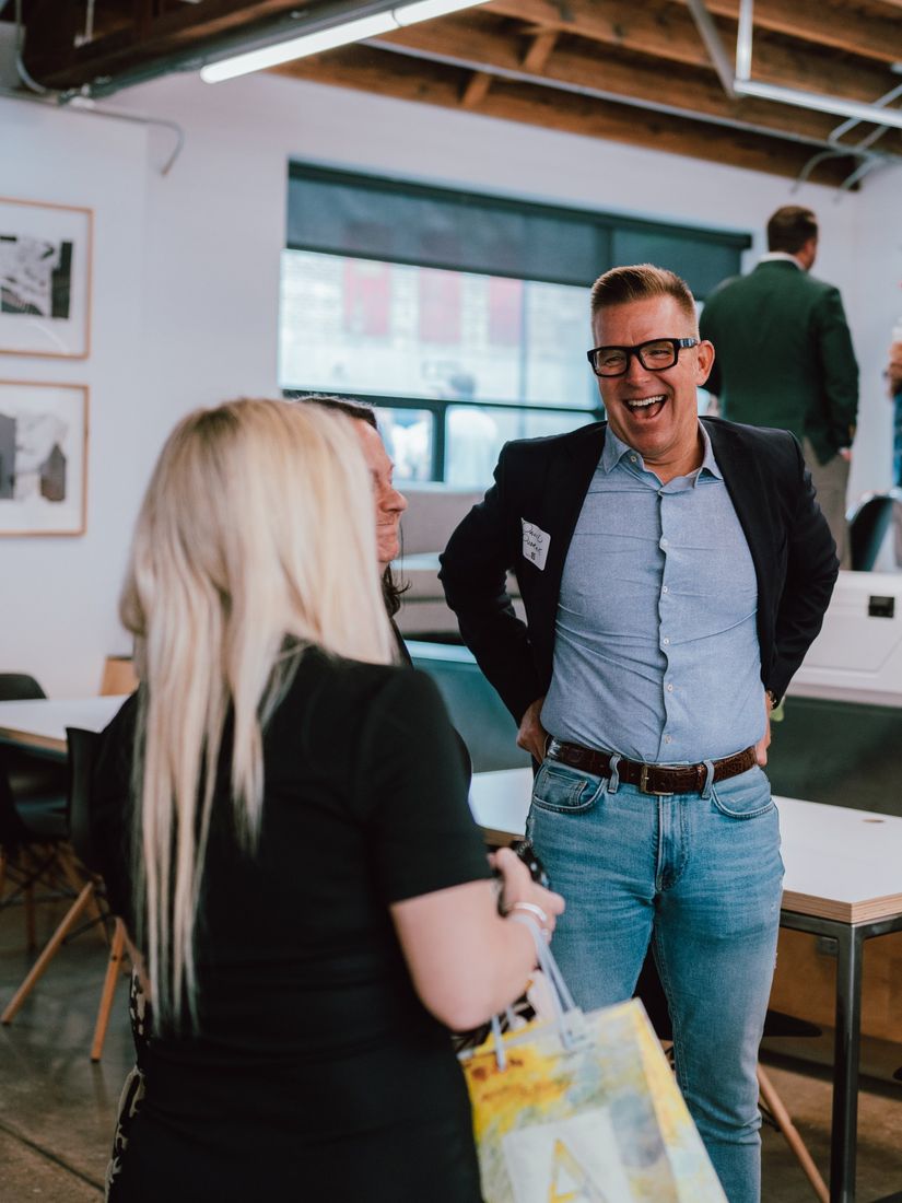 A guest laughing mid-conversation inside the TACK office
